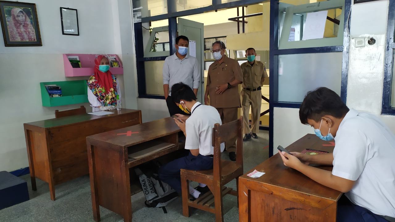 Supomo Kepala Dinas Pendidikan Kota Surabaya meninjau simulasi PBM tatap muka di SMPN 1 Surabaya, Senin (7/12/2020). (foto: Ind) 