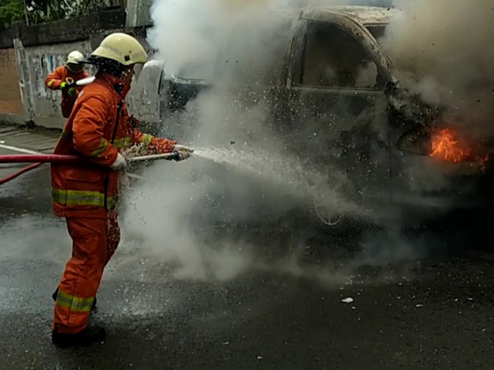 Petugas pemadam kebakaran saat memadamkan mobil yang terbakar di Jalan Dinoyo, Sabtu (20/2/2021) siang. 