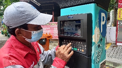 Juru parkir di kawasan Taman Bungkul saat menunjukkan cara menggunakan parkir meter.