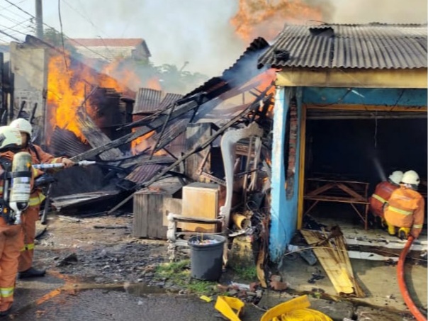 Petugas pemadam kebakaran saat memadamkan api sebuah toko mebel di Jalan Sukosemolo No 158 Surabaya 