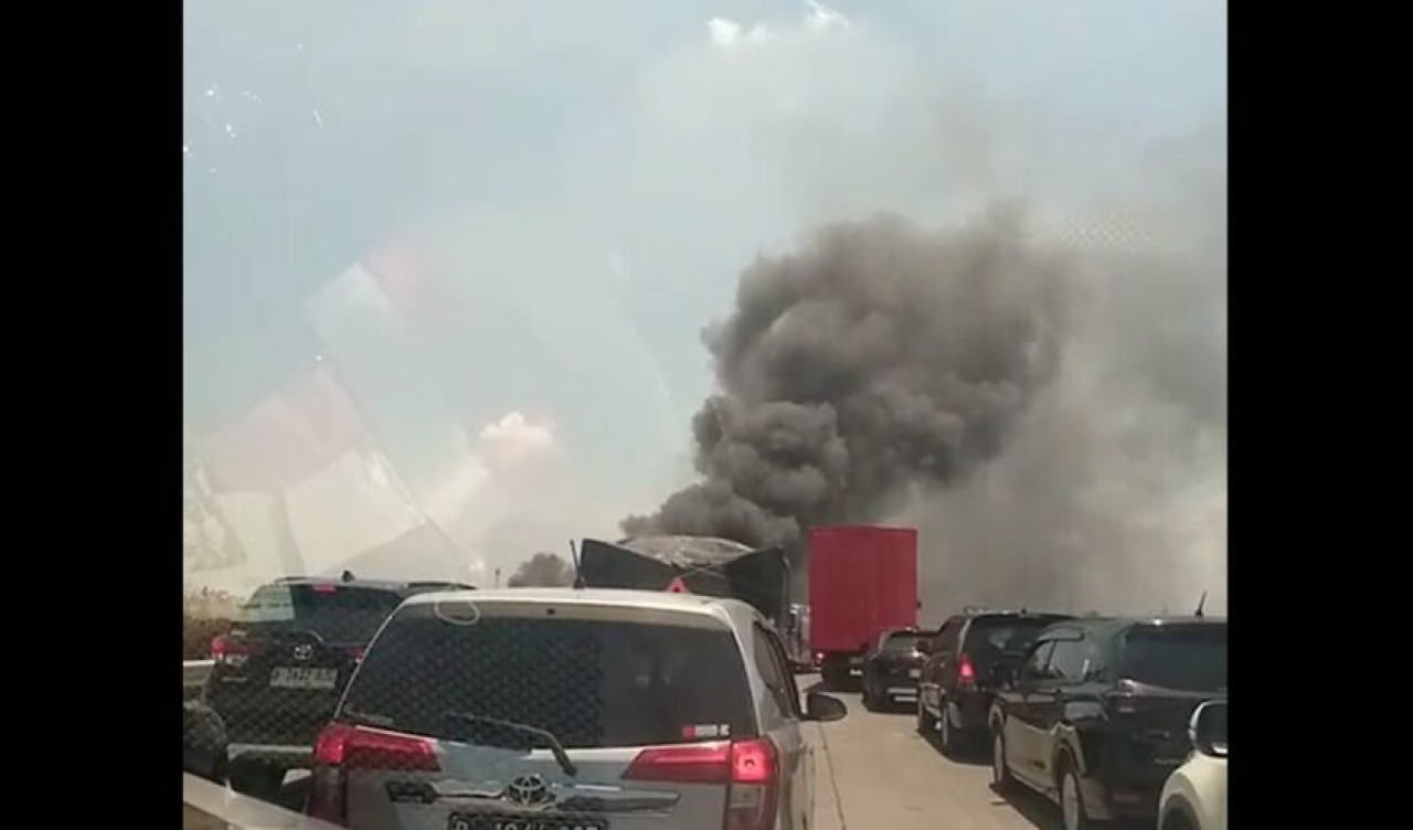 Asap hitam akibat kebakaran pabrik plastik di Driyorejo menutupi jala Tol Surabaya-Mojokerto (Sumo), Minggu (6/10/2024). Foto: Suara Surabaya