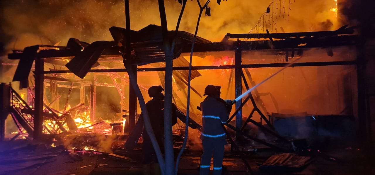 Petugas Damkar berjibaku memadamkan kobaran api di Kafe Mahkota di Babat, Lamongan