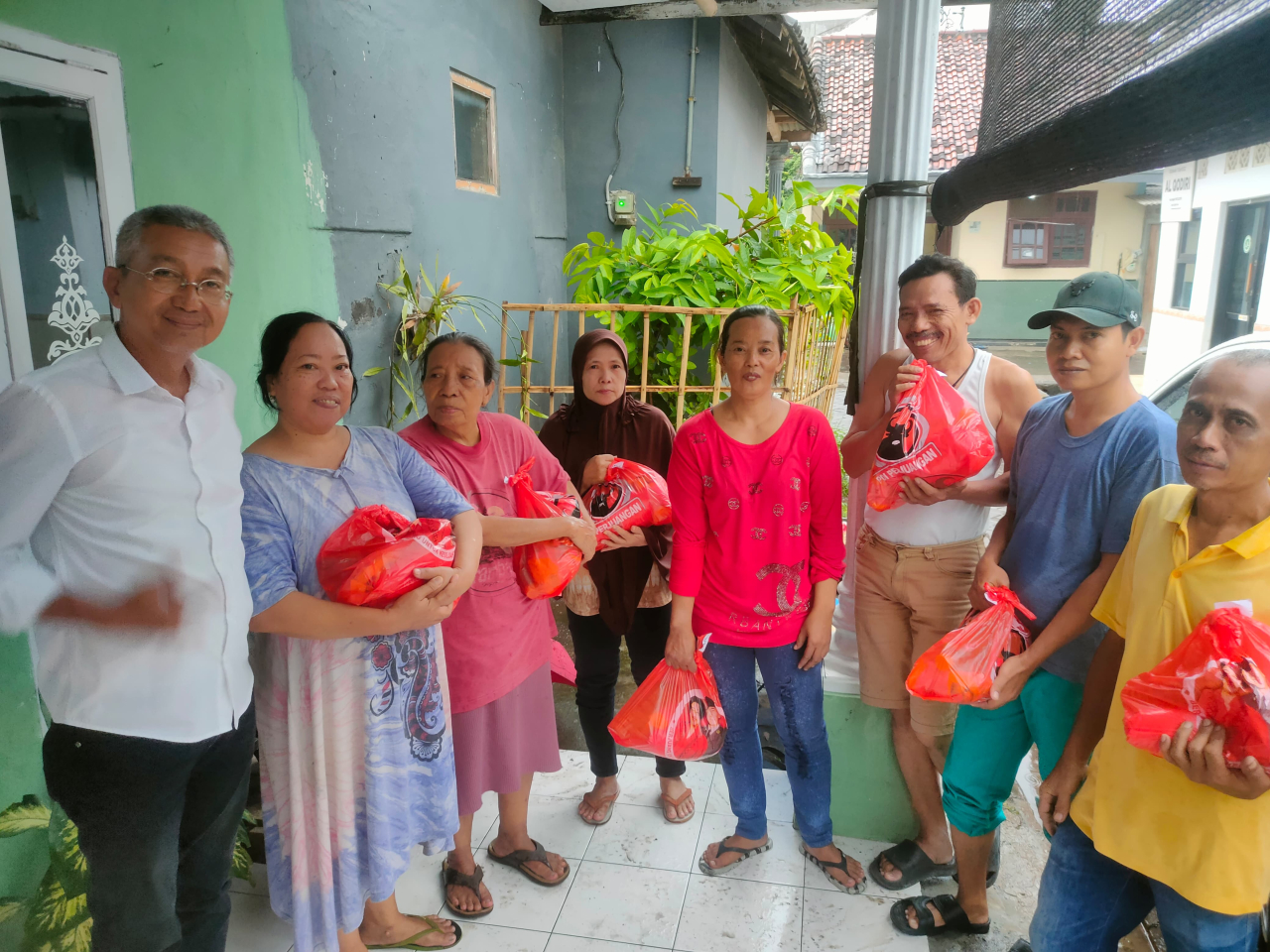Caption : Salah satu pengurus DPC PDI Perjuangan Kota Probolinggo saat membagikan paket sembako kepada masyarakat