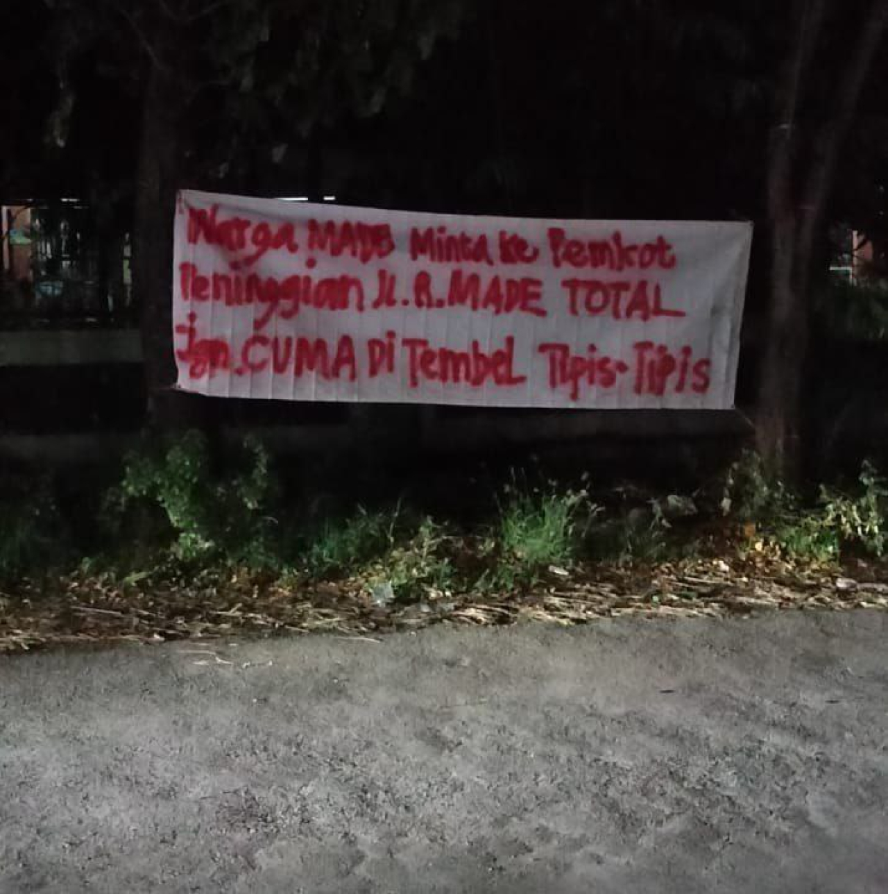 Spanduk protes warga karena jalan raya Made yang rusak