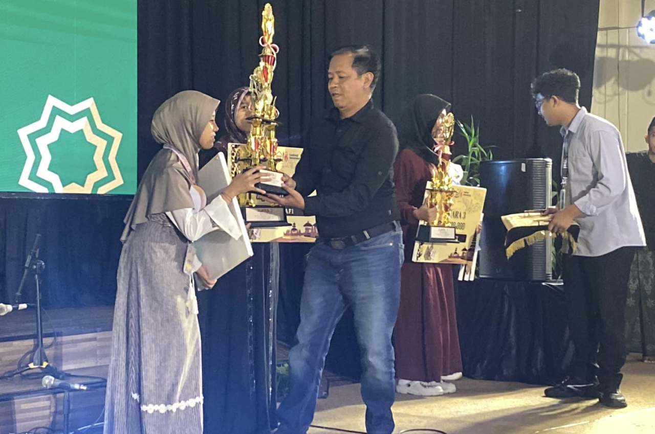 Auliatuz Zakiyyah, siswi kelas 10 A Sekolah Rakyat Terintegrasi 07 Probolinggo saat menerima piagam atas prestasinya pada juara 1 Festival Kaligrafi