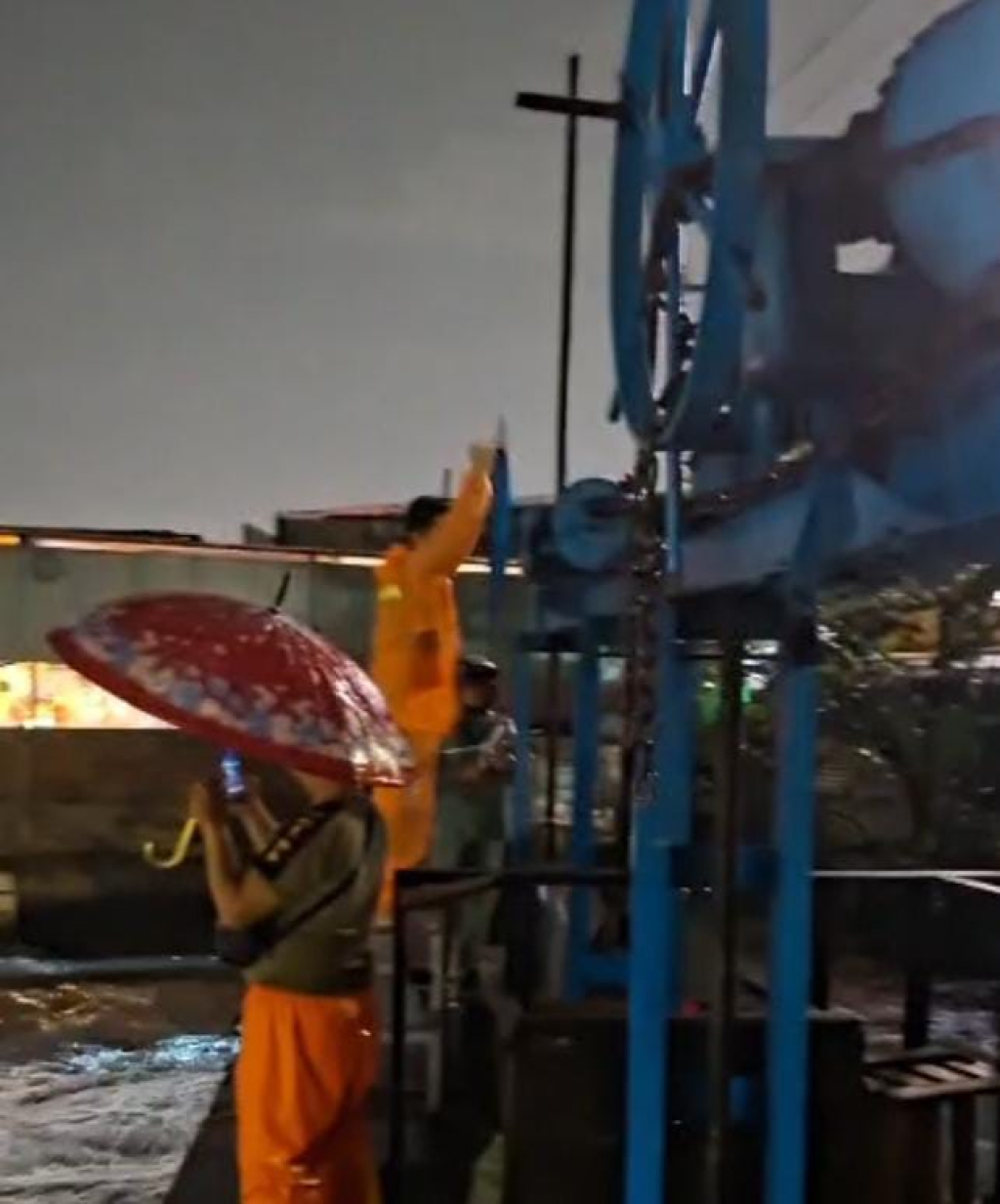 Camat Sukomanunggal, Dwi Anggara, turun langsung ke lapangan untuk membuka pintu air untuk mengatasi banjir di wilayahnya