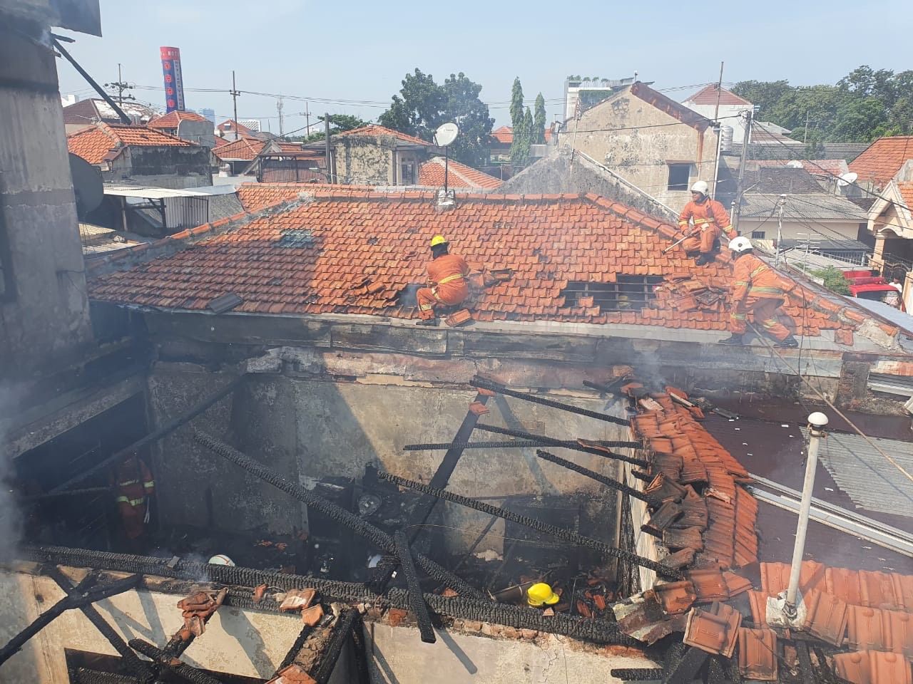 Petugas saat memadamkan api yang membakar rumah di Jalan Ngagel Timur No. 17 A, Kelurahan Pucang Sewu, Kecamatan Gubeng, Surabaya.