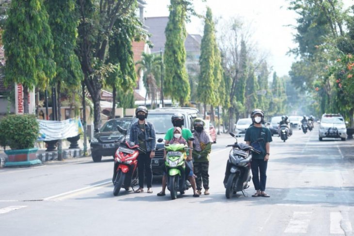 Warga mengambil sikap sempurna saat Mars Pancasila dikumandangkan di simpang jalan wilayah Kota Kediri, (Kominfo Kediri)