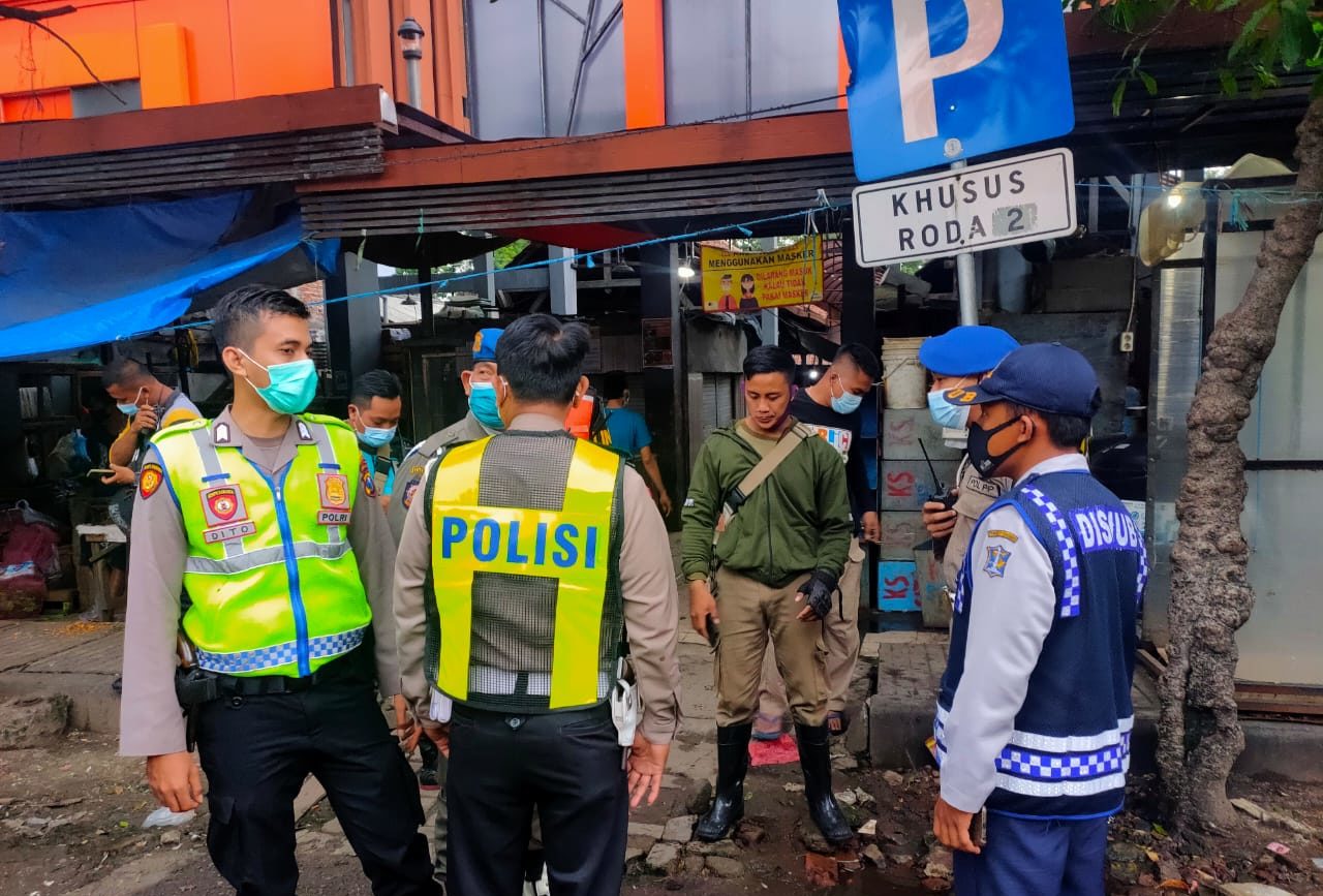 BERJAGA: Polisi di lokasi pengeroyokan di Traffic Light (TL) Demak, dekat Pasar Tembok, Surabaya, Sabtu (2/1/2021) sore. Foto: Command Center Surabaya
