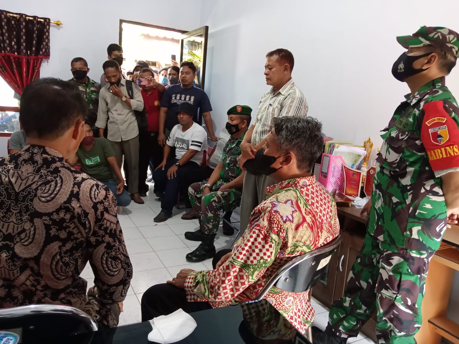 W (batik merah) saat diamankan oleh Polisi