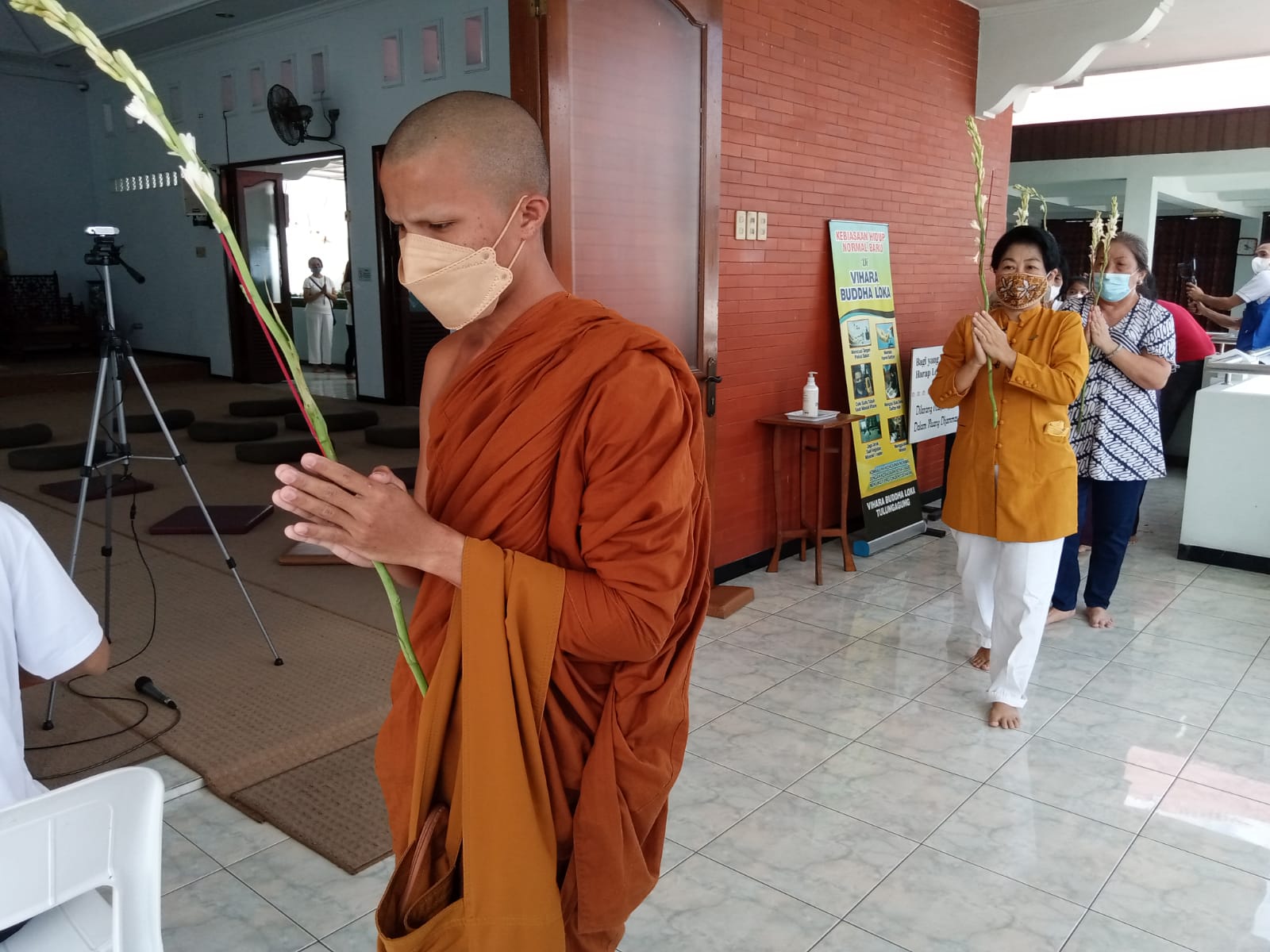 Samanera Phiadaso memimpin umat berkeliling Vihara sebelum acara Puja Bakti