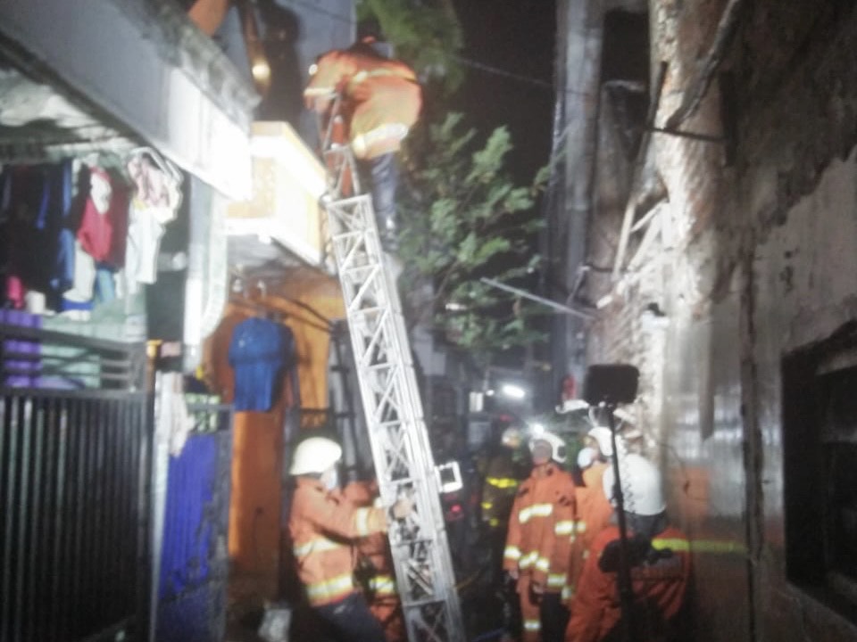 Petugas saat mengevakuasi korban di rumah yang terbakar akibat elpiji ngebros
