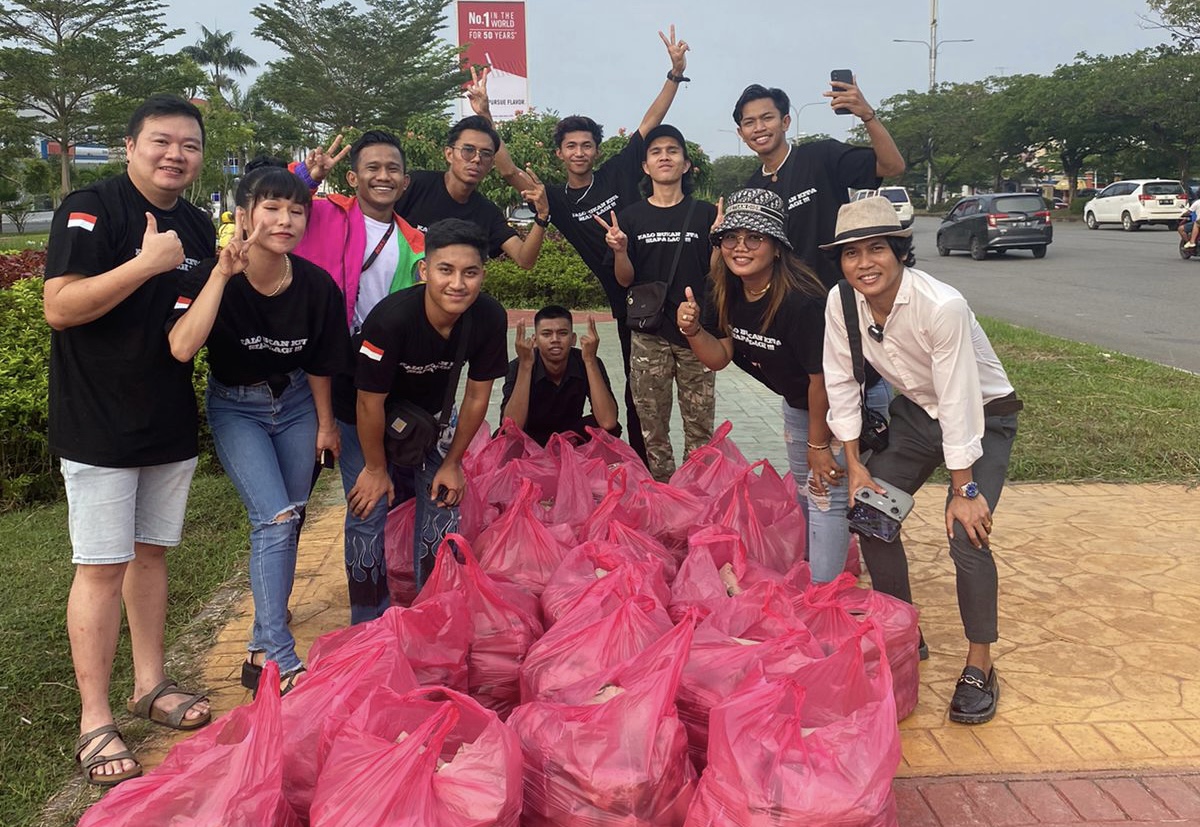 Ksatria Batam dan Sosialita Miss_Cawaii membagikan 1.000 nasi bungkus kepada para pengendara yang melintas di Simpang Gelail Batam Center