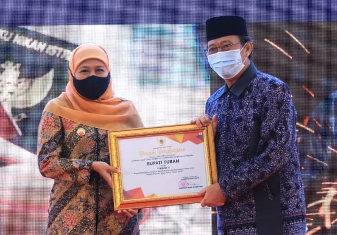 Gubernur Jatim Khofifah Indar Pawaransa menyerahkan penghargaan kepada Bupati Tuban H. Fathul Huda di Gedung Negara Grahadi, Surabaya, Selasa (6/4/2021) malam. (Foto: at5/ist/Bacasaja.id)