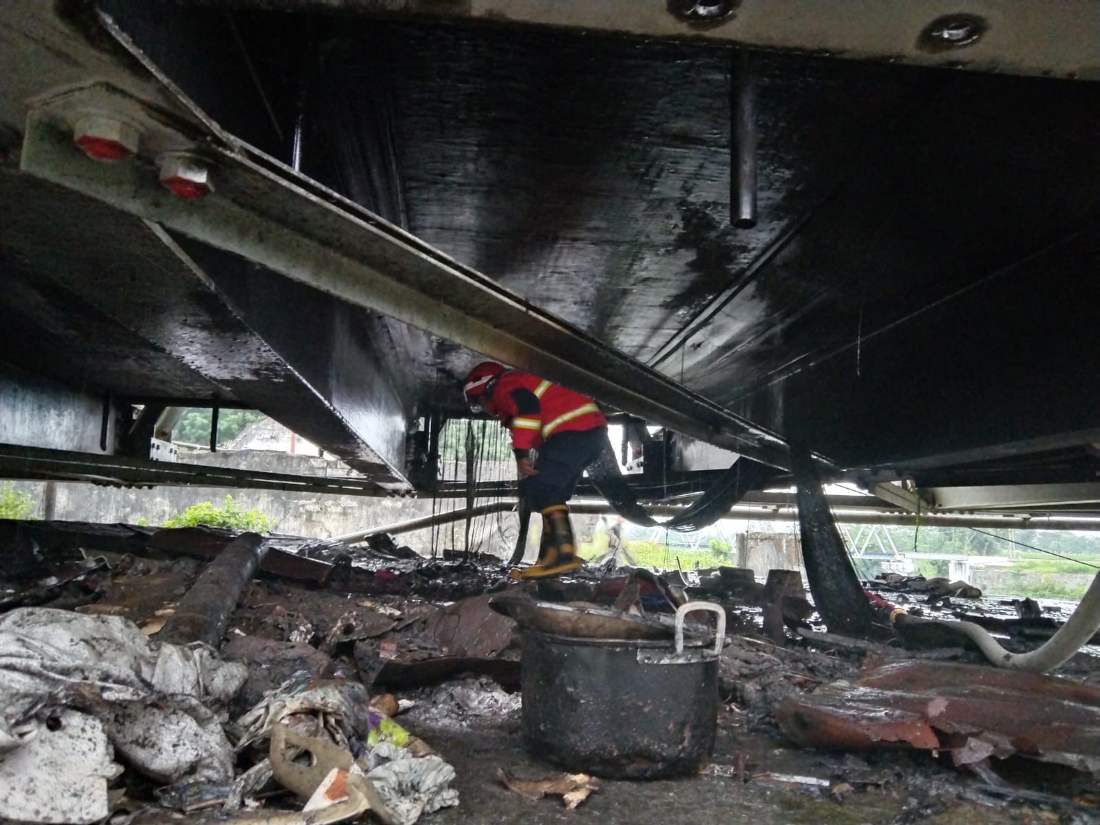 Petugas pemadam kebakaran memeriksa lokasi kebakaran di kolong Jembatan Ngujang 1