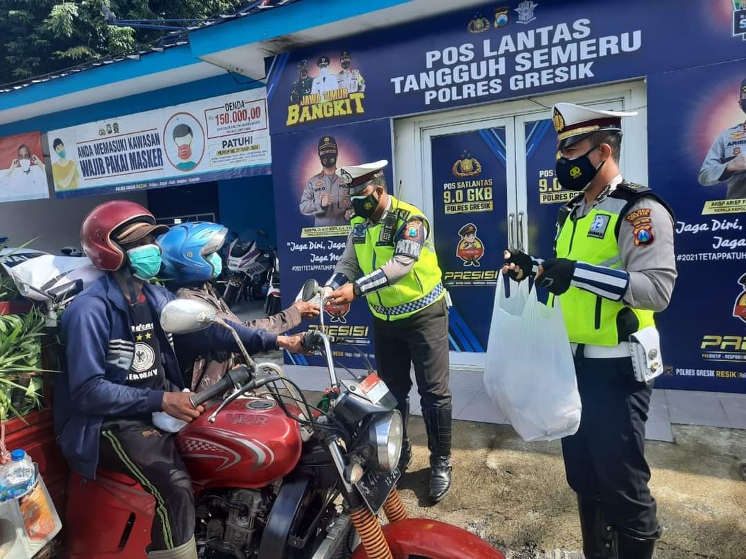 Anggota Sat Lantas Polres Gresik melakukan penempelan sticker dan nasi bungkus di salah satu Pos Lantas, Senin (22/2/2021). 