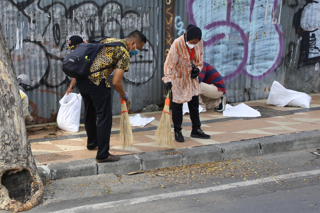 Walikota Surabaya, Tri Rismaharini saat membersihkan sampah di trotoar.