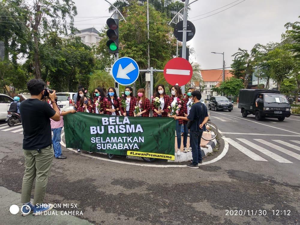 Perempuan milenial yang tergabung dalam ”Anak Muda Milenial Surabaya” atau disingkat Amelia, berbagi bunga mawar kepada pengendara motor. (foto: jem) 