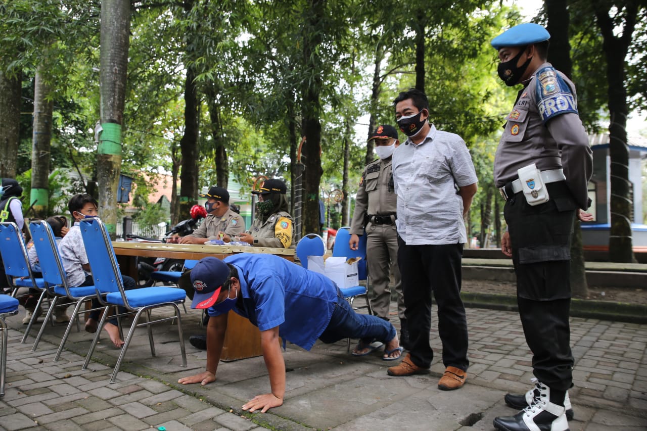 Petugas memberikan sanksi pushup pelanggar protokol kesehatan/Istimewa.
