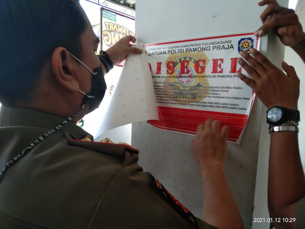 Petugas menyegel salah satu toko modern berjaringan di Kabupaten Tulungagung, beberapa waktu lalu.