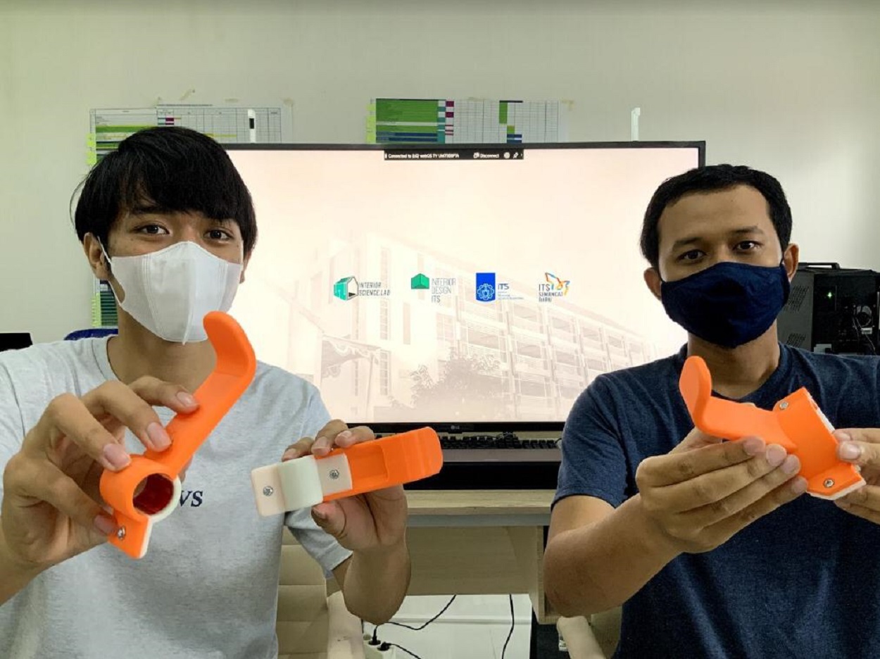 Okta Putra Setio Ardianto ST MT bersama mahasiswa Departemen Desain Interior ITS menunjukkan alat bantu gangang pintu anti Covid - 19 rancangannya