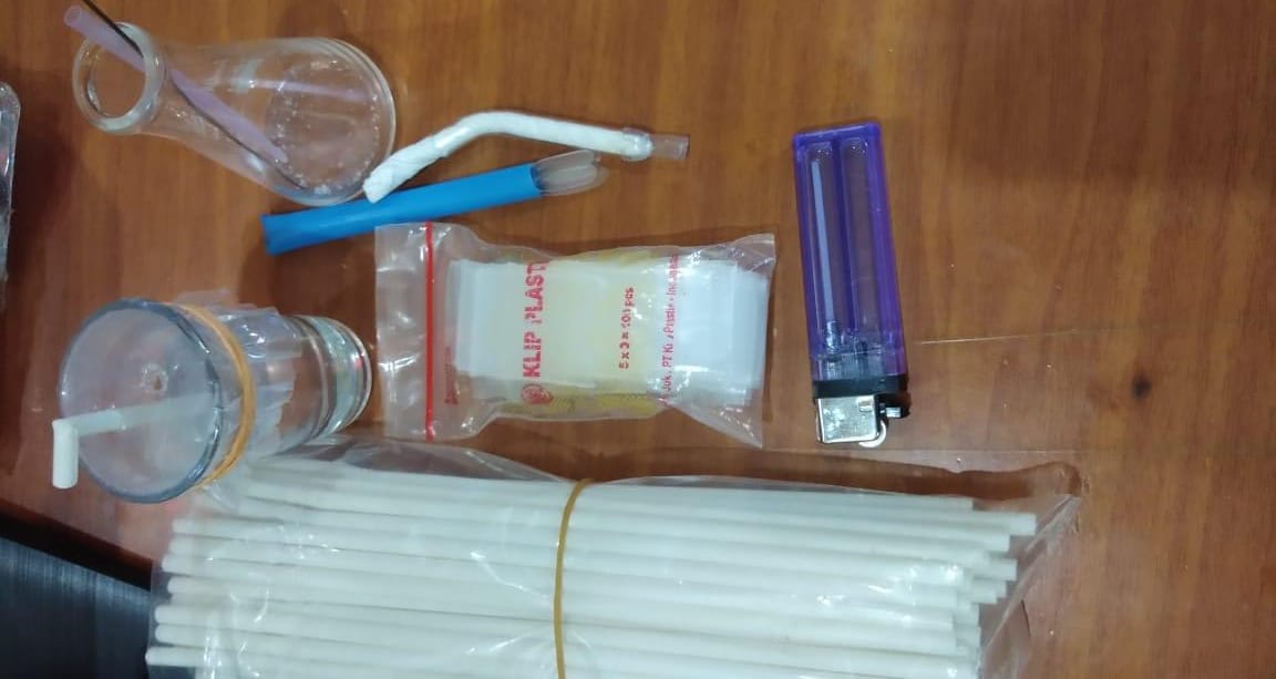 Barang bukti satu botol bkng dan sedotan plastik yang digunakan Boneng mengisap sabu saat digrebek di rumahnya.