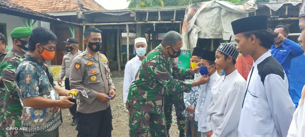 Danramil Mojowarno secara langsung mengenakan masker ke para santri Pondok Pesantren Darus Salam. | ftr/bacasaja.id