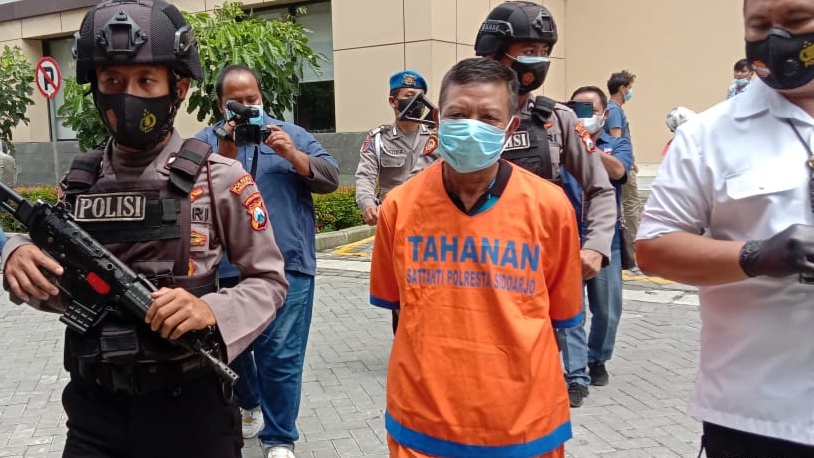 Jupri (tengah) pelaku penganiayaan karena cinta segitiga digiring ke ruang tahanan Polresta Sidoarjo.