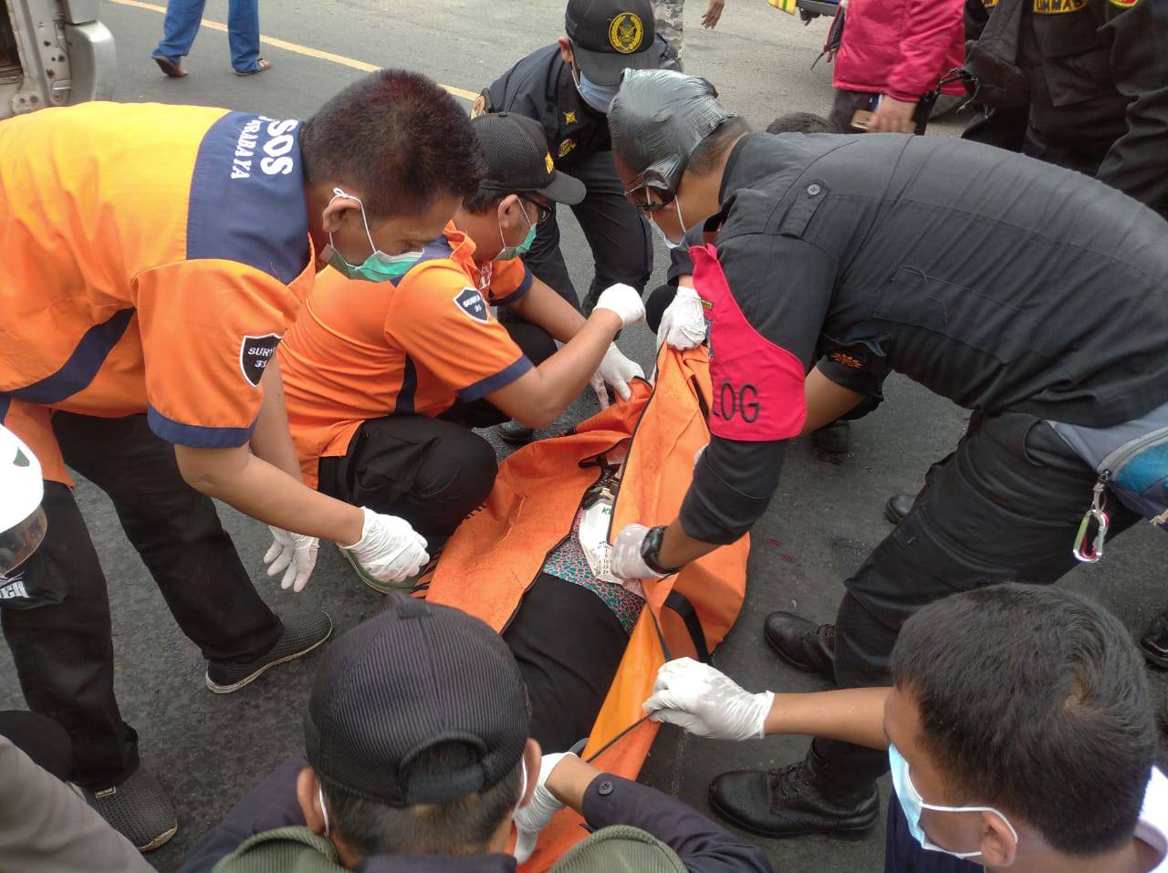 Petugas saat mengevakuasi korban kecelakaan yang meninggal di lokasi setelah terlindas truk. 