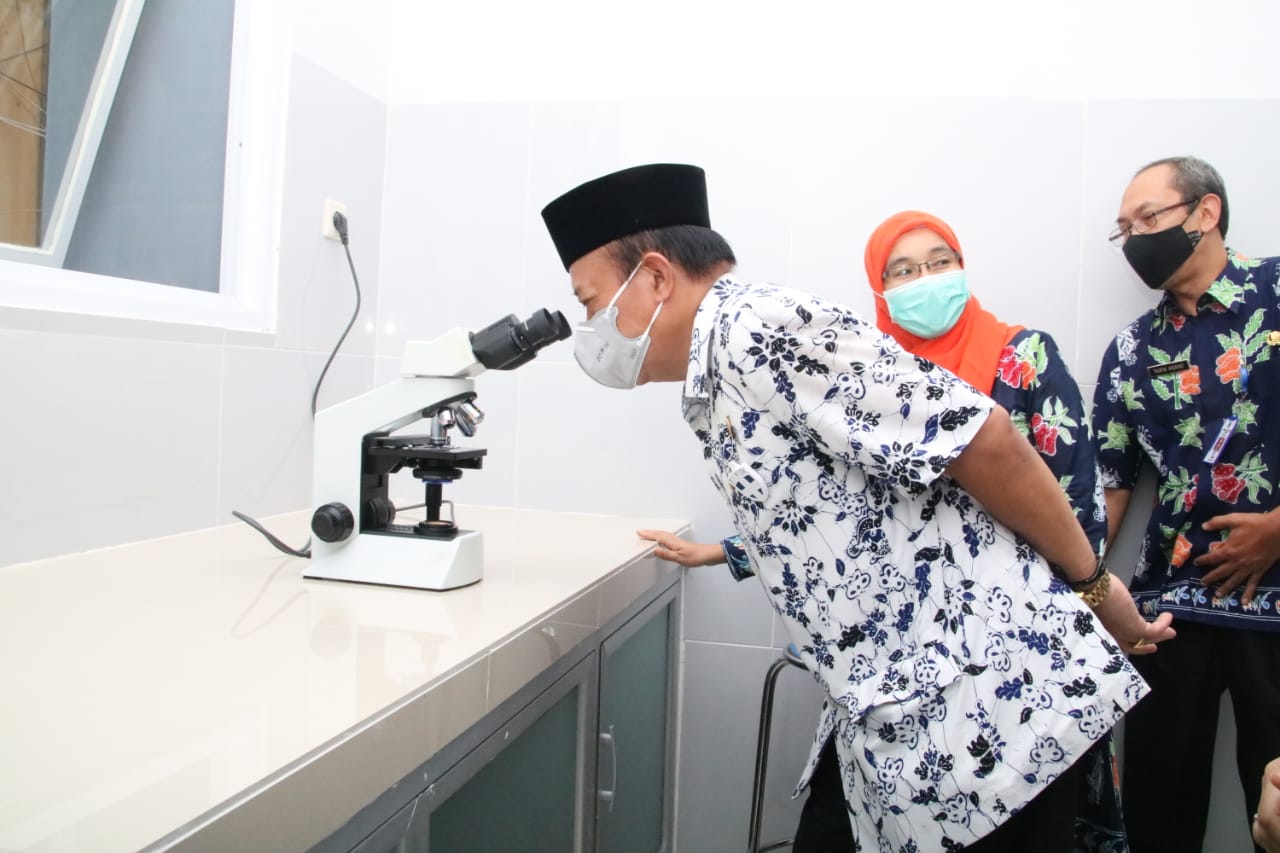 Bupati Lamongan, Fadeli ketika mencoba salah satu alat yang ada di Laboratorium Kesehatan Daerah (Labkesda), Sabtu (13/2/2021) setelah diresmikan. (Ichol/BACASAJA.ID)