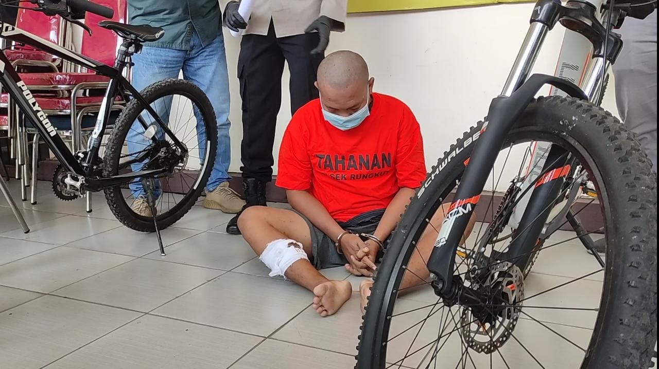 Eko beserta dua sepeda ontel hasil curiannya saat diamankan Polsek Rungkut. 