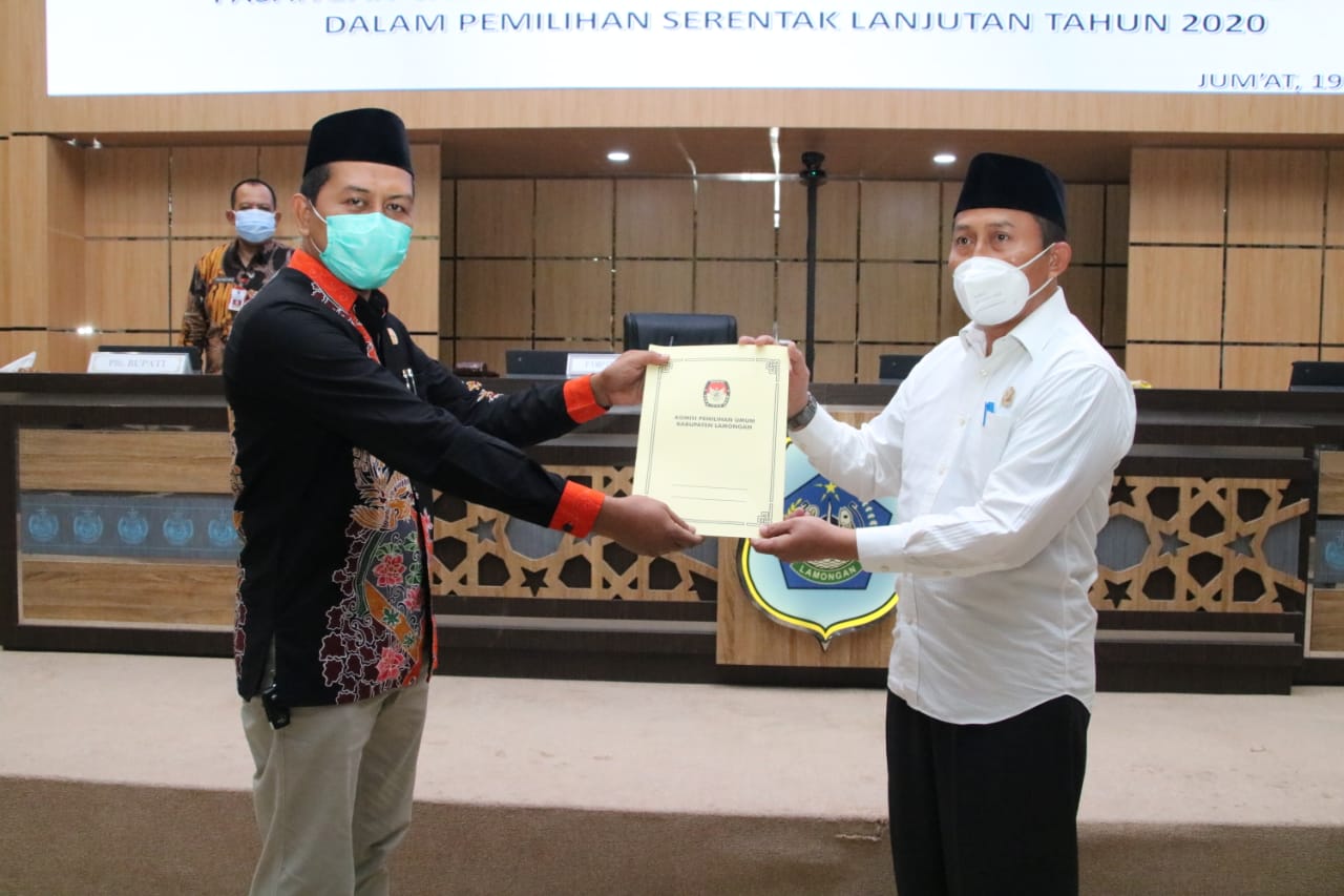 Ketua KPU Mahrus Ali (kiri) menyerahkan Keputusan resmi Bupati Lamongan terpilih ke DPRD Lamongan, Jumat (19/2/2021) dikantor DPRD. (Ichol/ Bacasaja.id)