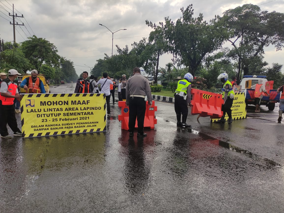 Petugas saat melakukan penutupan Jalan Raya Porong lama oleh BBPJN VIII untuk mengurangi endapan air. 