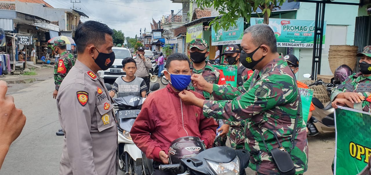 Kapolsek Mojowarno dan Danramil 0814/15 Mojowarno saat memakaikan masker.