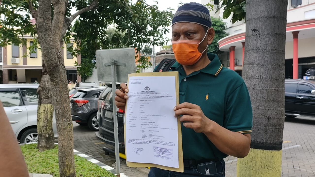 Sasminto saat menunjukan bukti laporan di Polrestabes Surabaya.