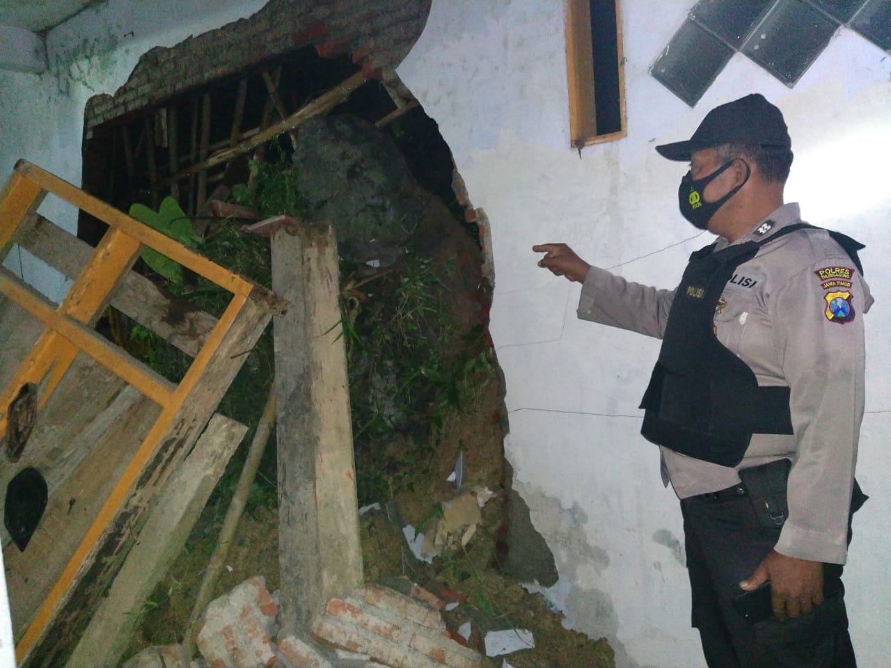 Polisi mengecek rumah di Desa/Kecamatan Pagerwojo, Kabupaten Tulungagung yang tertimpa longsor. (Foto : Noyo/Bacasaja.id)