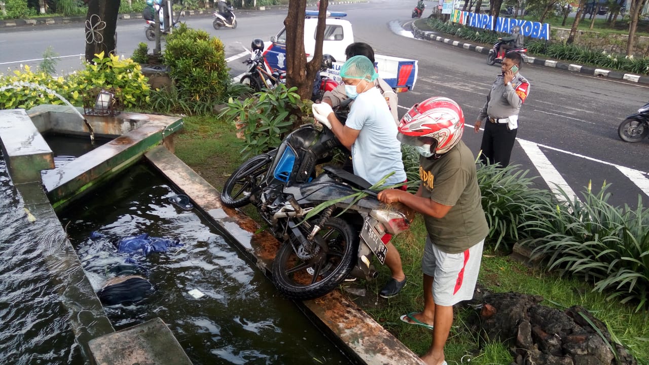 Motor korban yang tercebur ke dalam kolam taman jalan.
