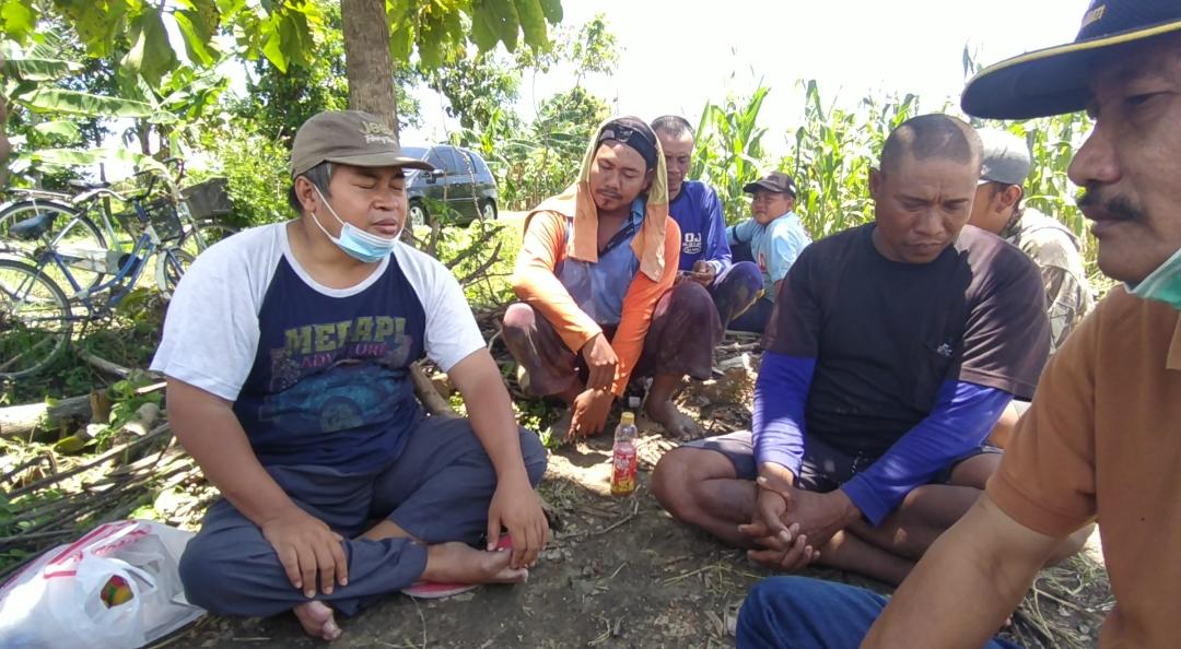 Ansori berbincang dengan petani di areal persawahan.