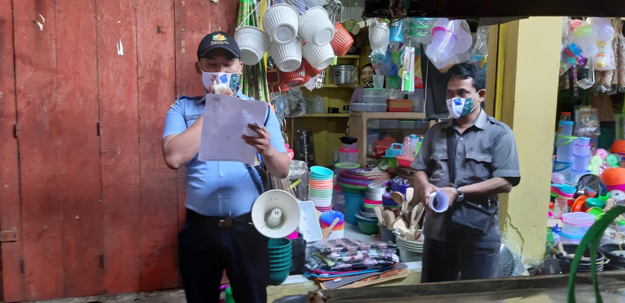 Petugas PD Pasar Surya saat melakukan sosialisasi kepada para pedagang pasar di Surabaya.