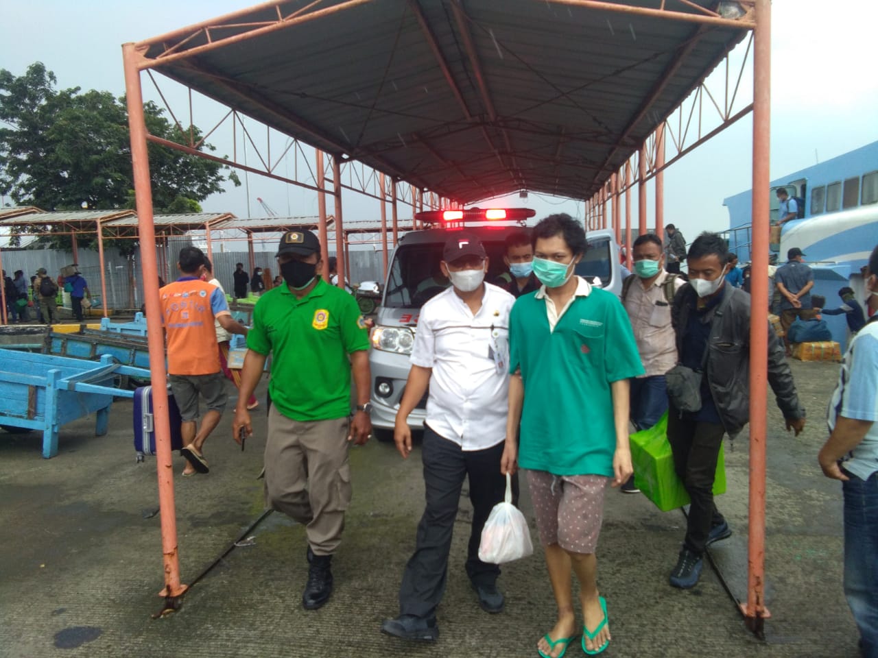 Dinsos Gresik saat menjemput ODGJ berinisial M (kaos Hijau) dari pulau Bawean saat tiba di pelabuhan Gresik, Jumat (19/3/2021).