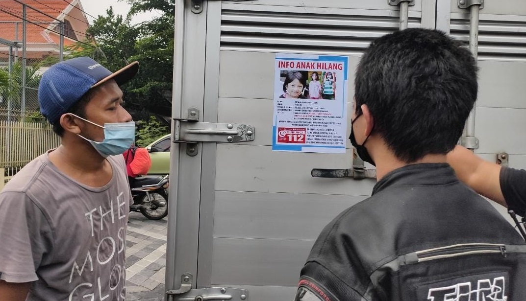 Petugas aat menempel poster di mobil box