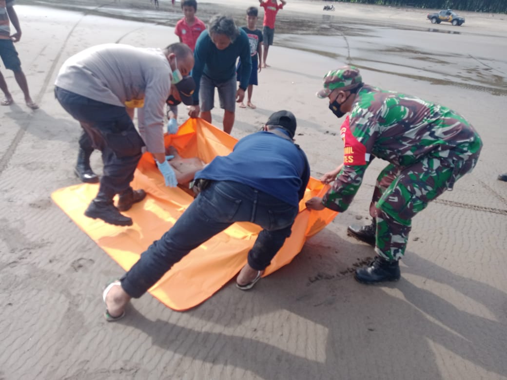Petugas kepolisian dan TNI saat mengevakuasi jenazah yang tenggelam akibat terseret ombak di Pantai Jolosutro, Blitar, Senin (29/3/2021). Foto: Istimewa