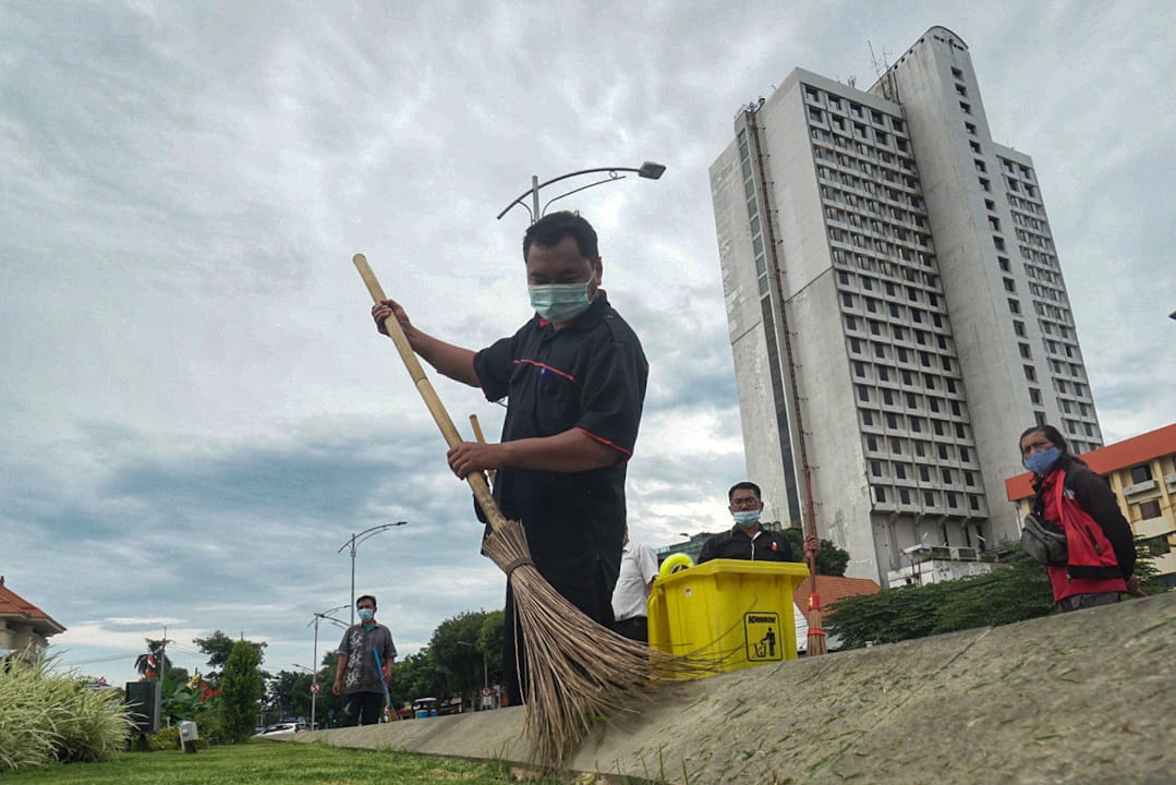 Petugas saat membersihkan area taman kota