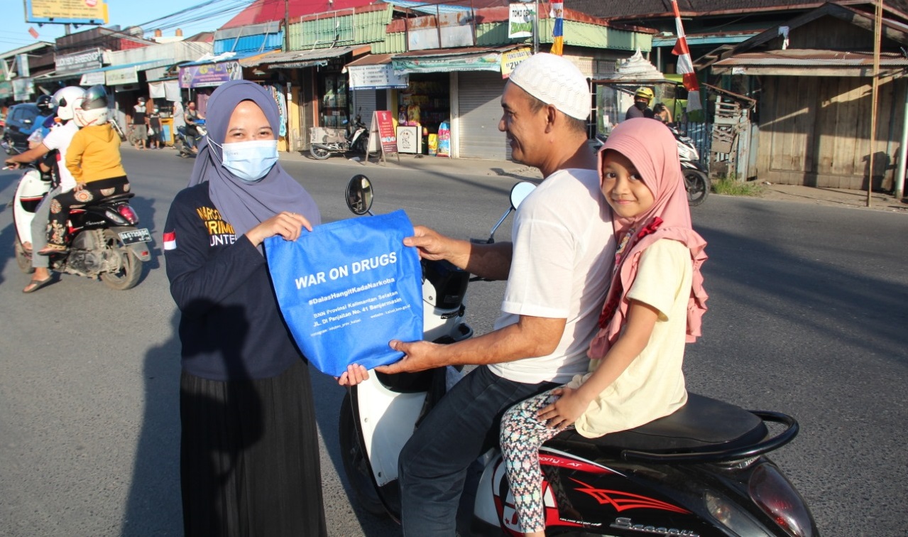 salah satu anggota Forpan memberikan bingkisan kepada salah satu pengendara.