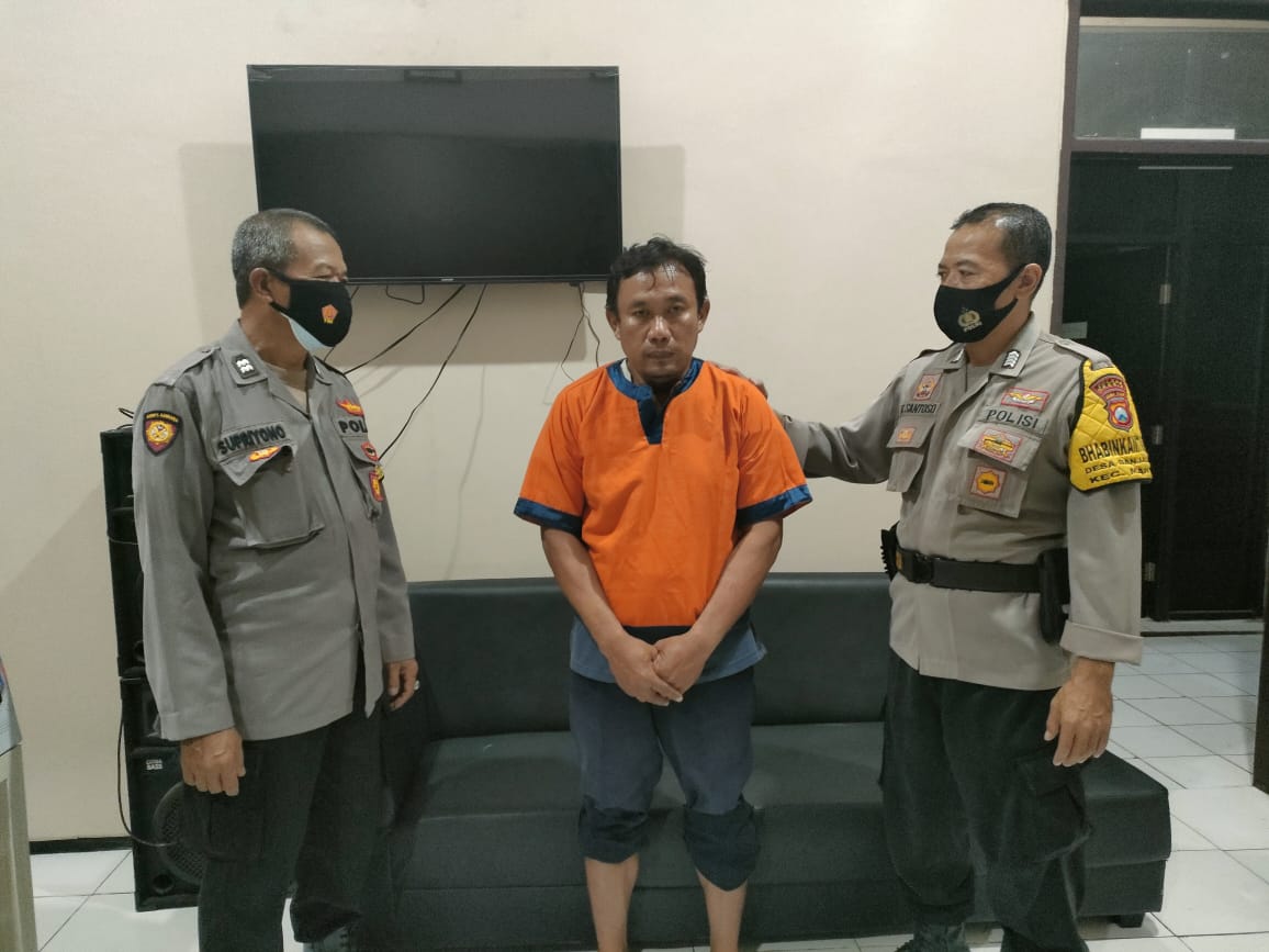 Pelaku pencurian Tri Yono diapit dua anggota Polsek Manyar, Gresik, Rabu (28/4/2021). 