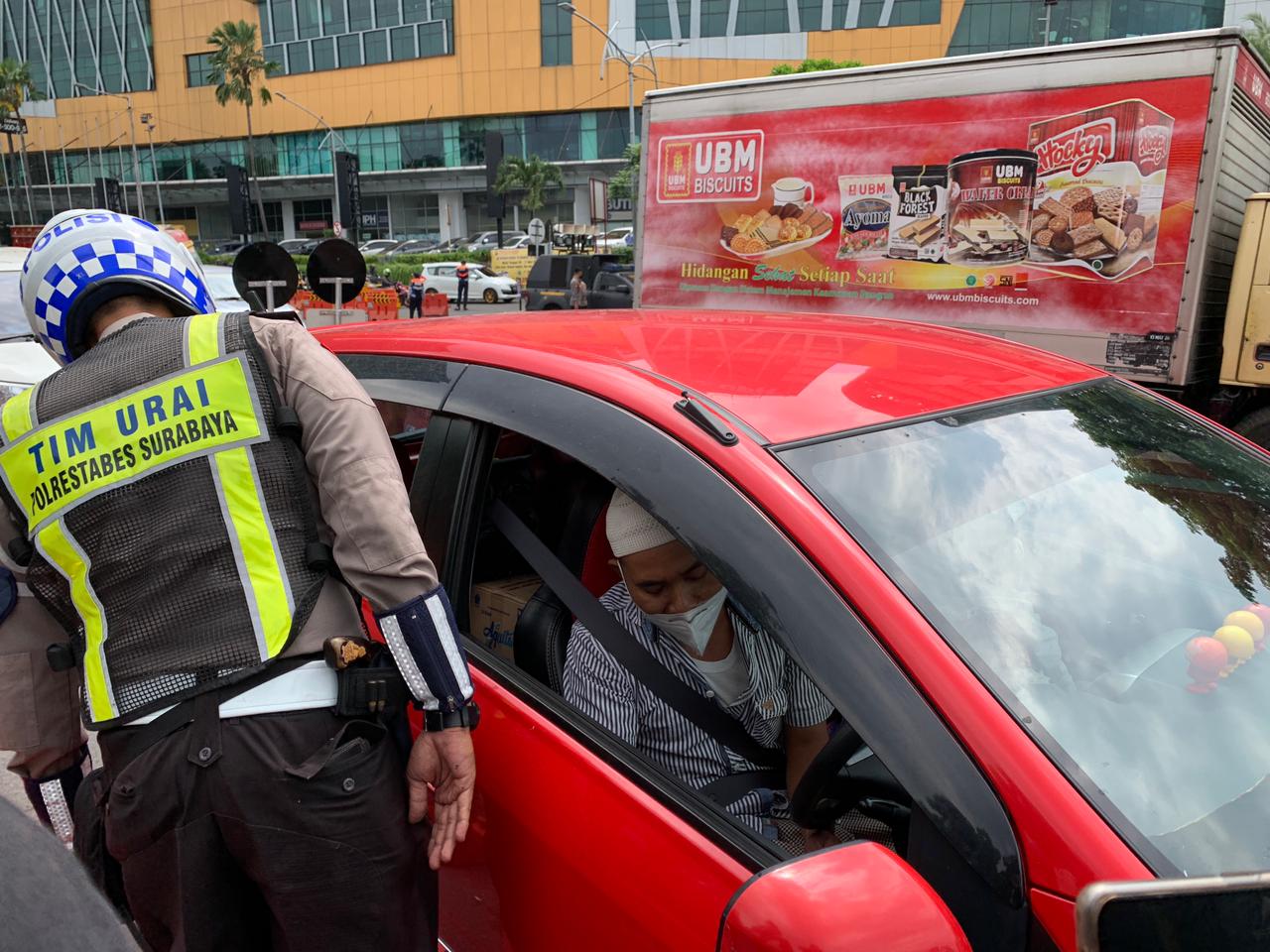 Petugas saat mengecek pengendara mobil berplat luar Surabaya di titik penyekatan Bundaran Waru dekat Mal Cito, Surabaya, Kamis (29/4/2021). 