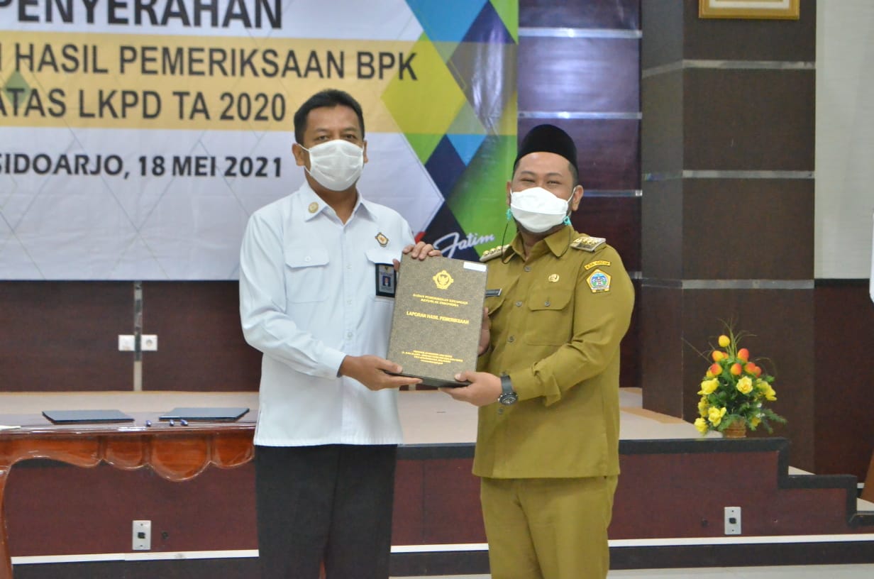 Bupati Gresik Fandi Akhmad Yani saat menerima buku laporan WTP di BPK Jawa Timur, Selasa (18/5/2021).