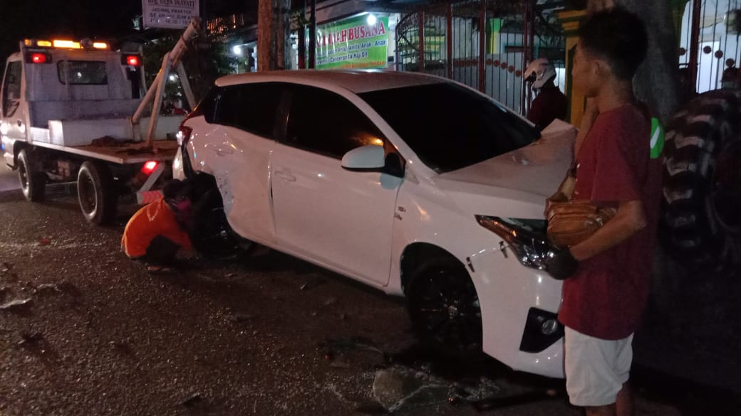 Petugas saat mengevakuasi mobil yang terlibat kecelakaan menggunakan derek.
