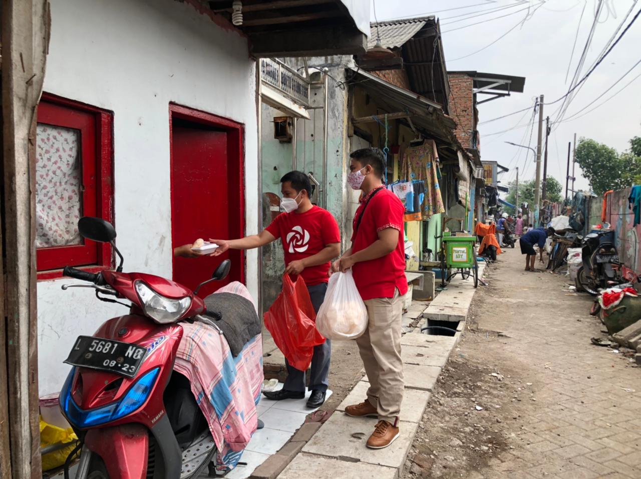 Anggota PSI Kota Surabaya saat membagikan makanan gratis.