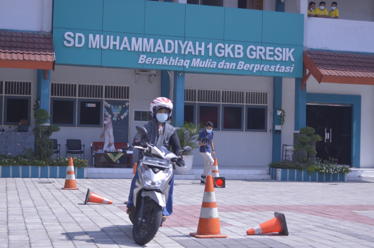 Seorang wali murid sedang mempraktekkan safety riding di halaman sekolah, Jumat (11/6/2021).